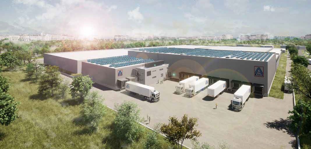 Vogelperspektive eines ALDI-Logistikzentrums mit Photovoltaikanlage auf dem Dach und mehreren LKW an den Laderampen.